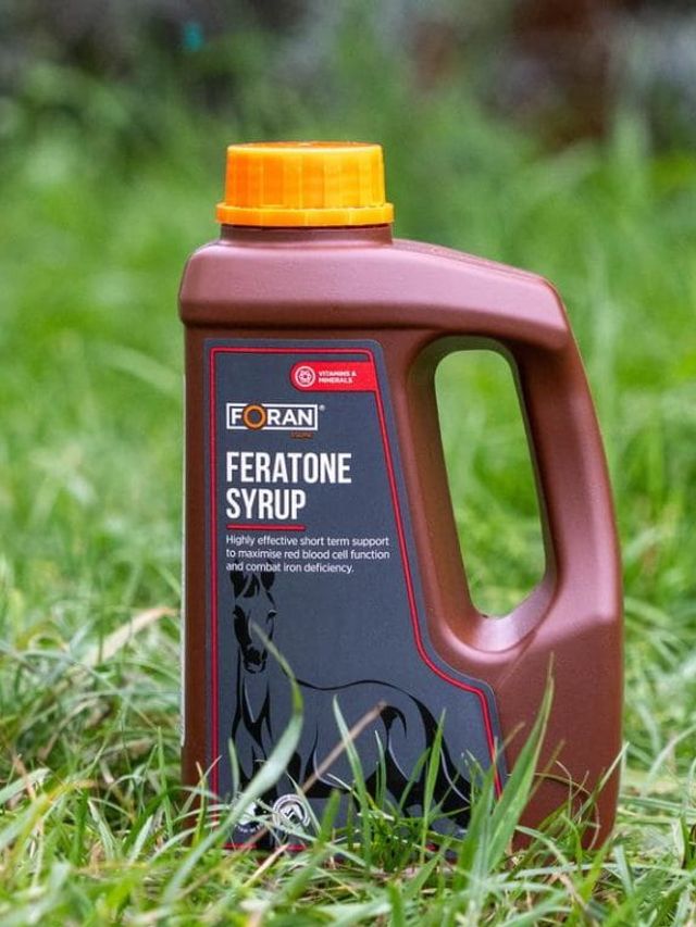 Foran Feratone Syrup 1 l – brązowa butelka syropu na niedobory żelaza, ustawiona w trawie